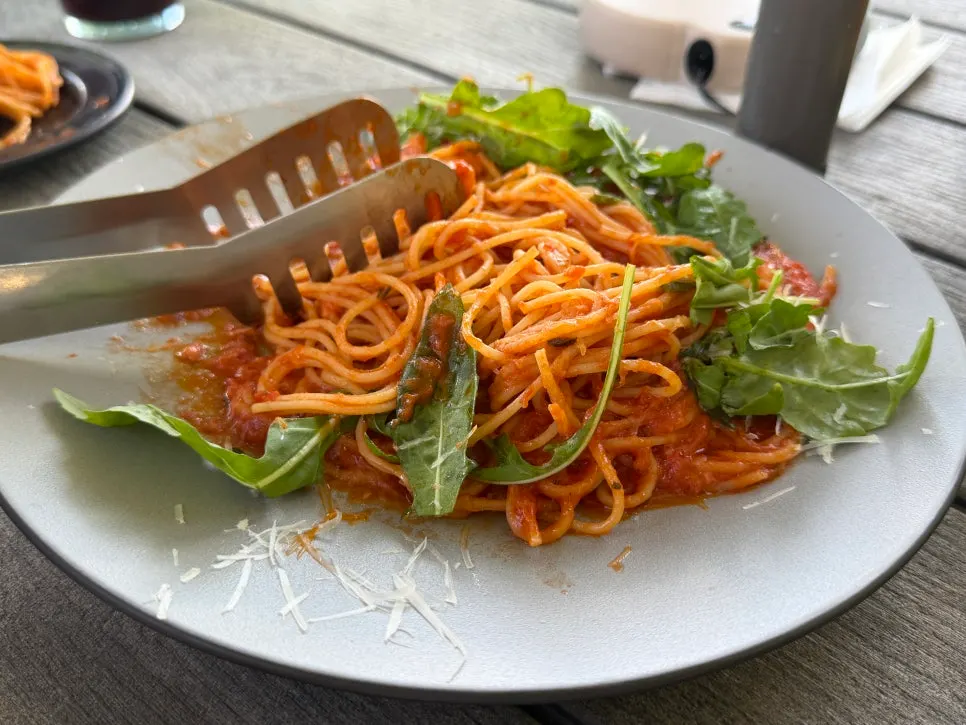 Shrimp tomato pasta topped with arugula