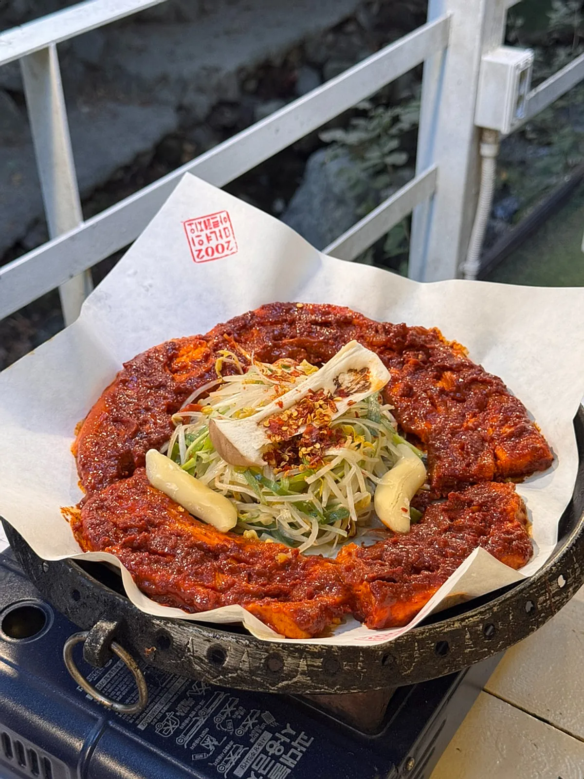 Two servings of tomato-jang pork belly on the grill