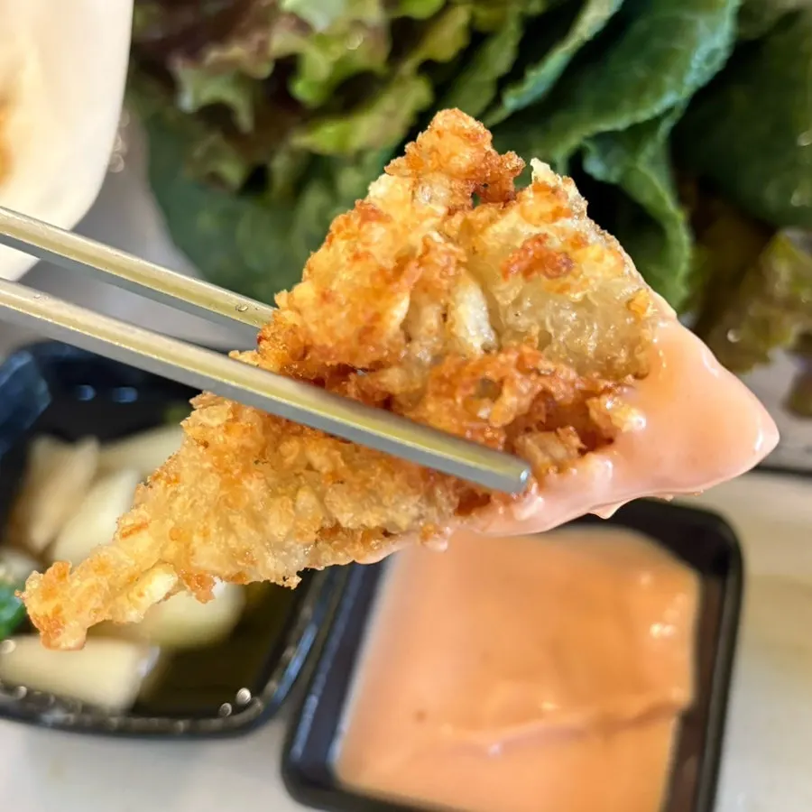 Piece of potato pancake dipped in buldak mayo sauce