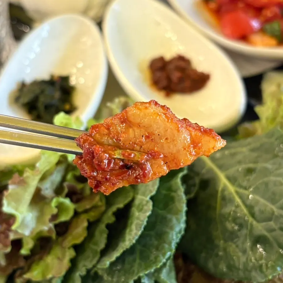 Close-up of a piece of tomato-jang pork belly