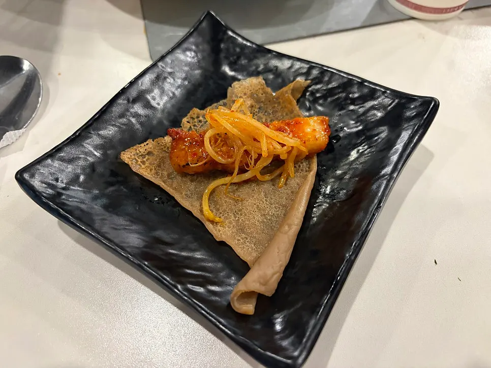 Pork belly wrapped in wheat crepe with raw seaweed
