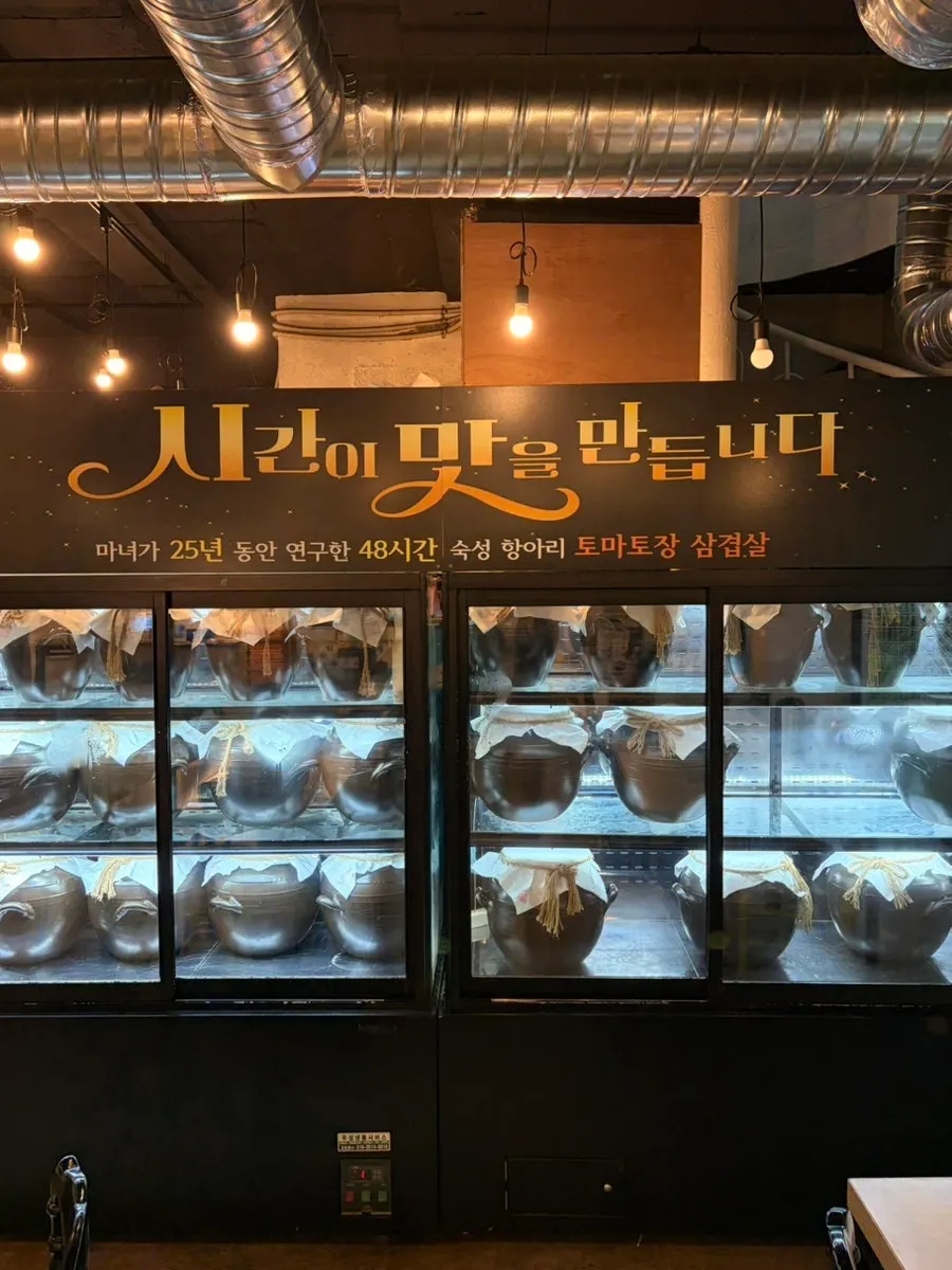Jars of tomato-jang aging pork belly inside the restaurant