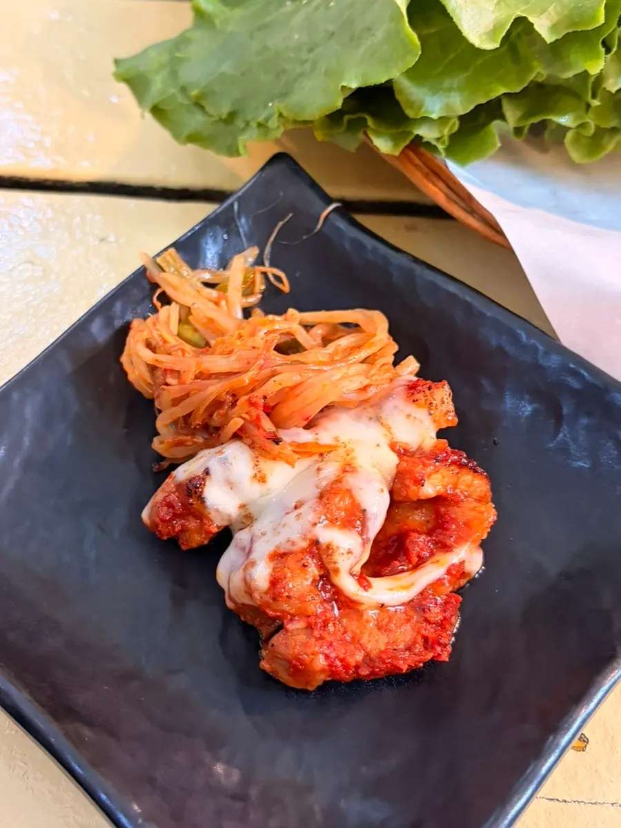 Finished tomato-jang pork belly topped with cheese
