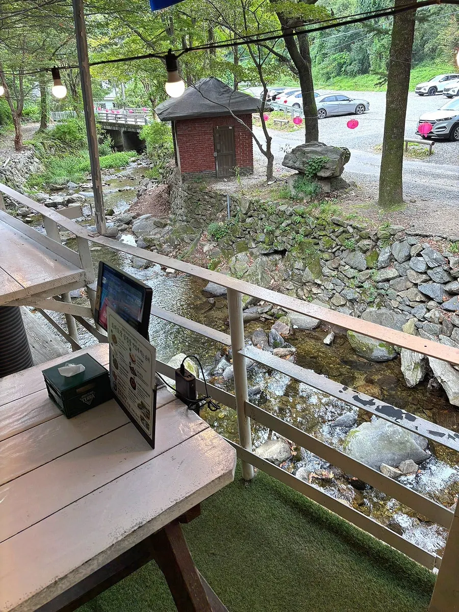 Outdoor BBQ seating with a creek view in autumn atmosphere