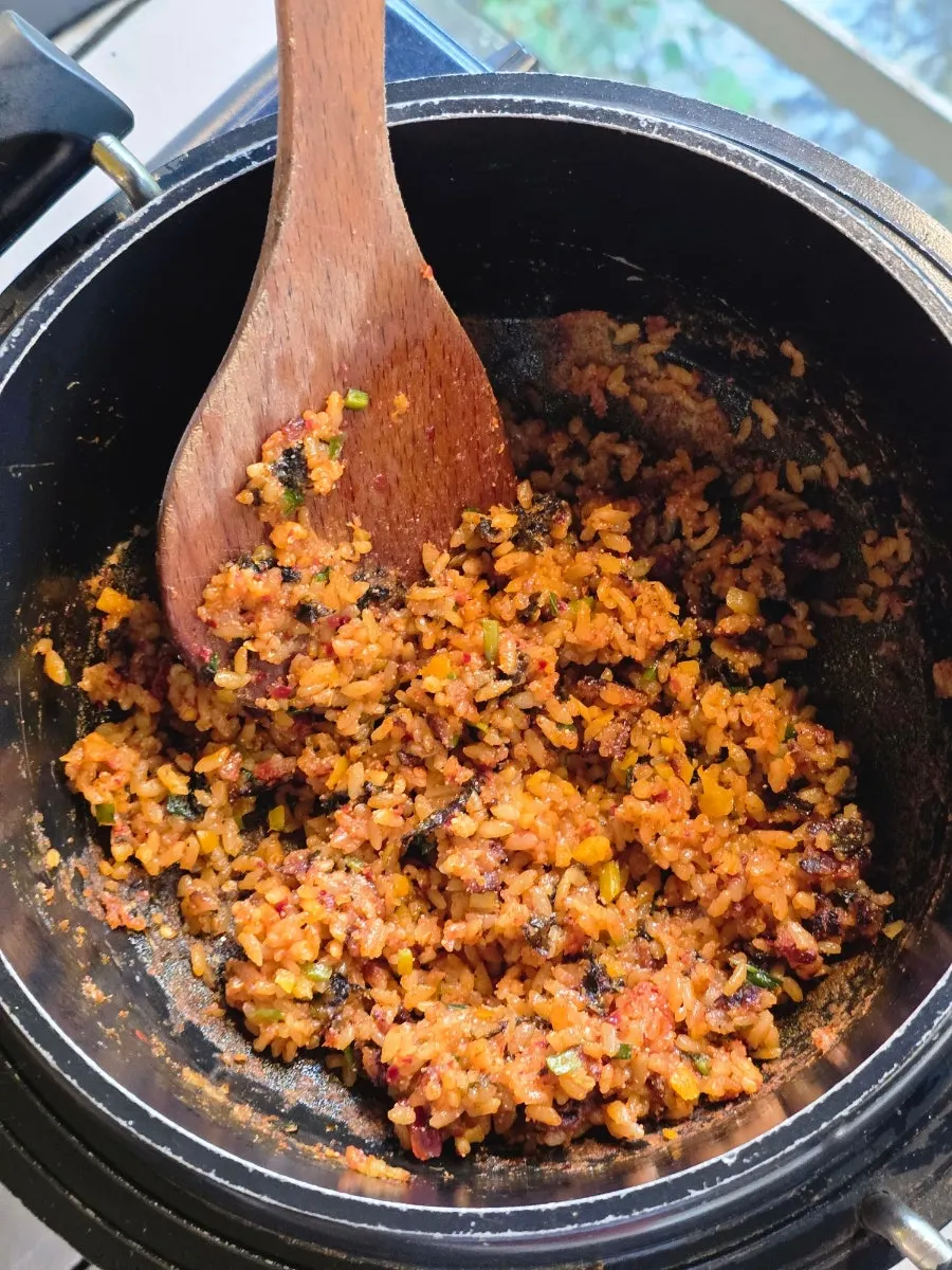 Pollack roe and scorched rice fried rice being made in a cast-iron pot