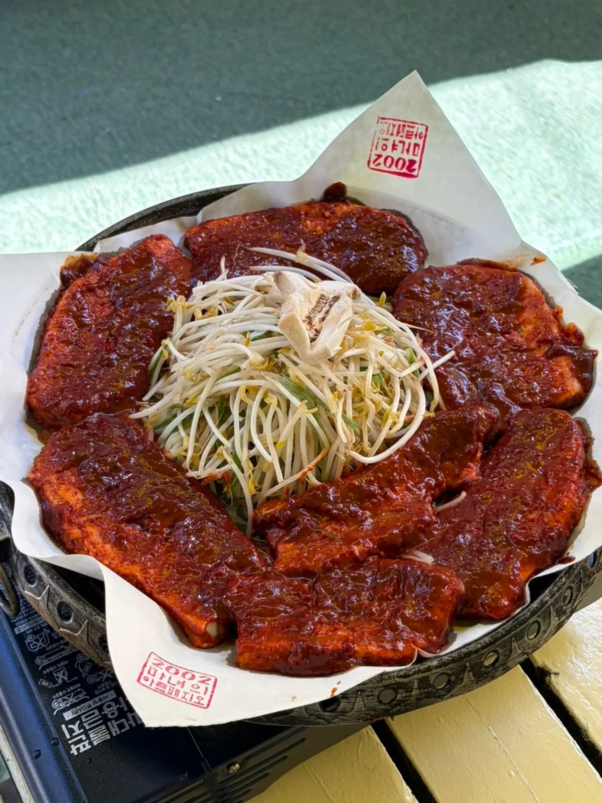 A full spread of tomato-jang pork belly with organic wrap vegetables