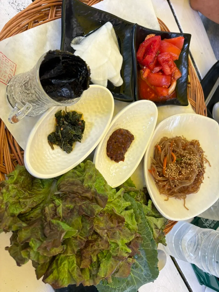 Acorn jelly pancake, tomato kimchi, and japchae side dishes