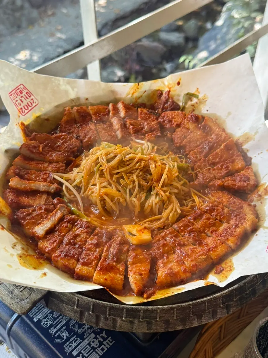 Tomato-jang pork belly cooking on the grill
