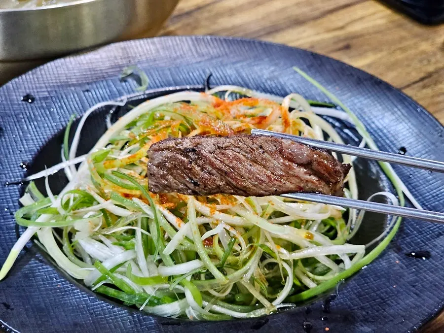 Aged hanwoo sirloin eaten with scallion salad