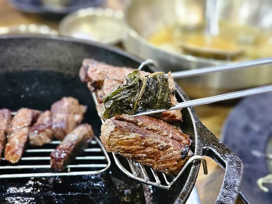 A piece of meat wrapped in lightly grilled perilla leaf pickle