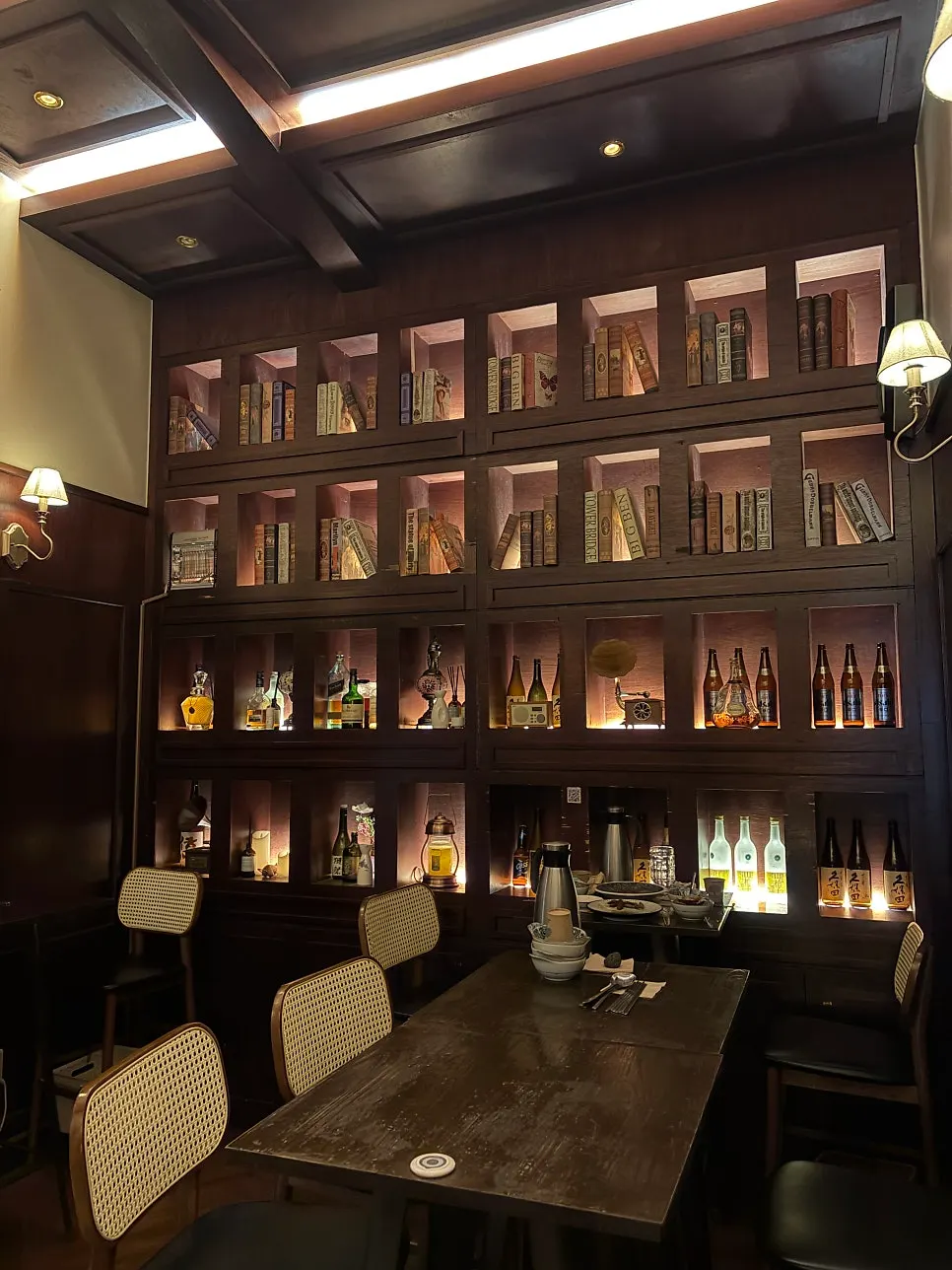 Wall filled with bookshelf props and bottles on display