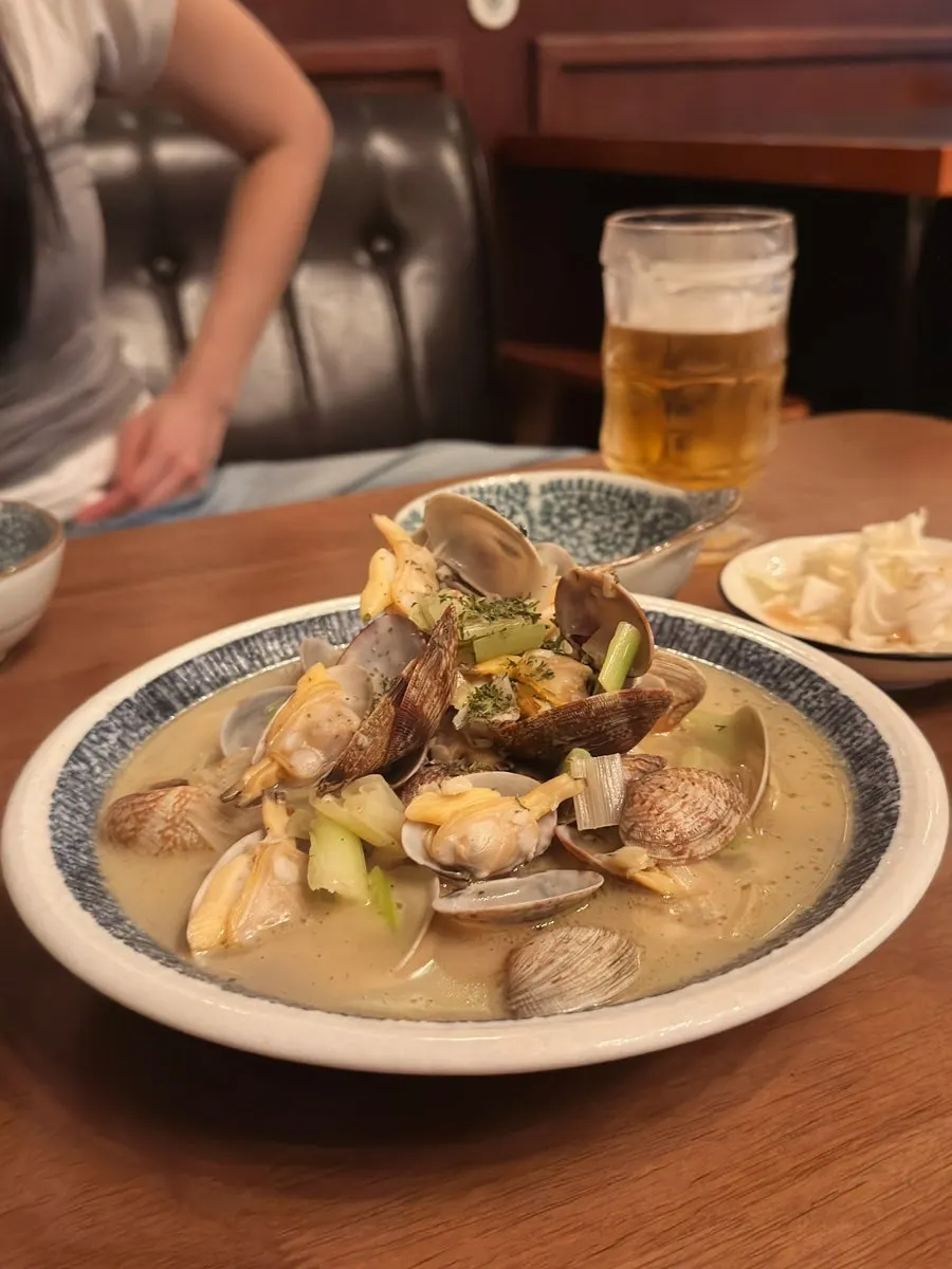 Table spread of steamed clams, cucumber muchim, and grilled beef intestine