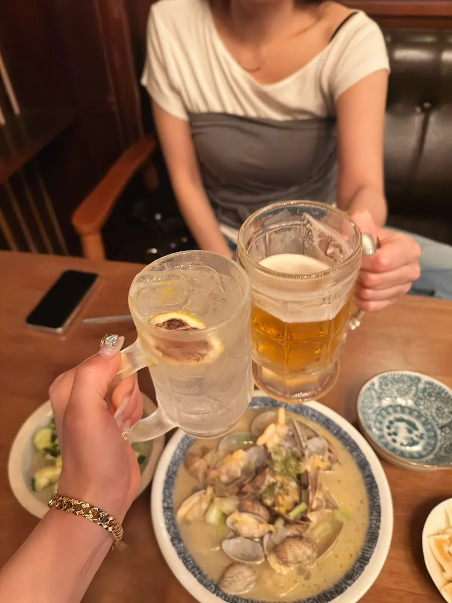 Toasting with a glass of cider and a glass of beer