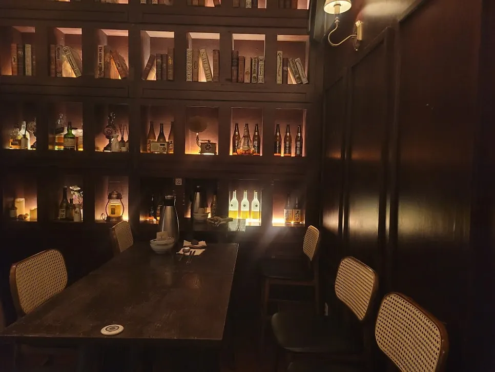 Wooden shelf interior with books and liquor bottles
