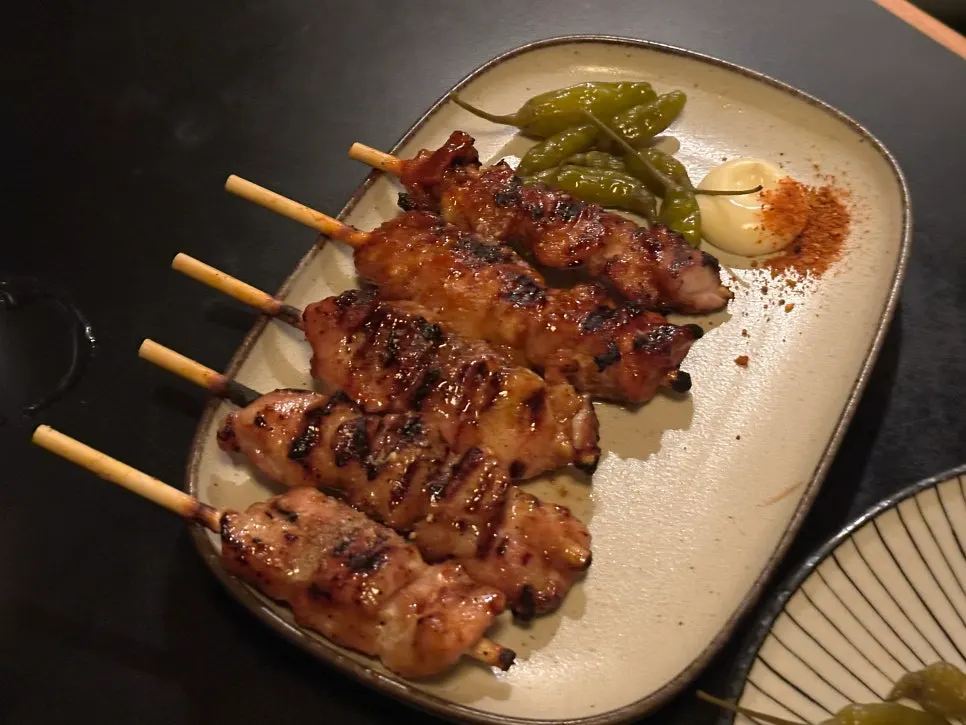The table digging into the pork belly and scallion skewers