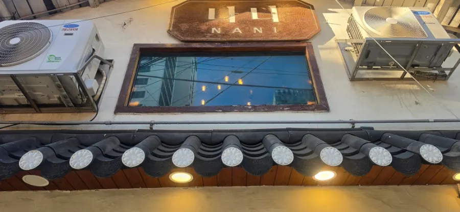 나무문과 기와 장식이 있는 나니별관 외관