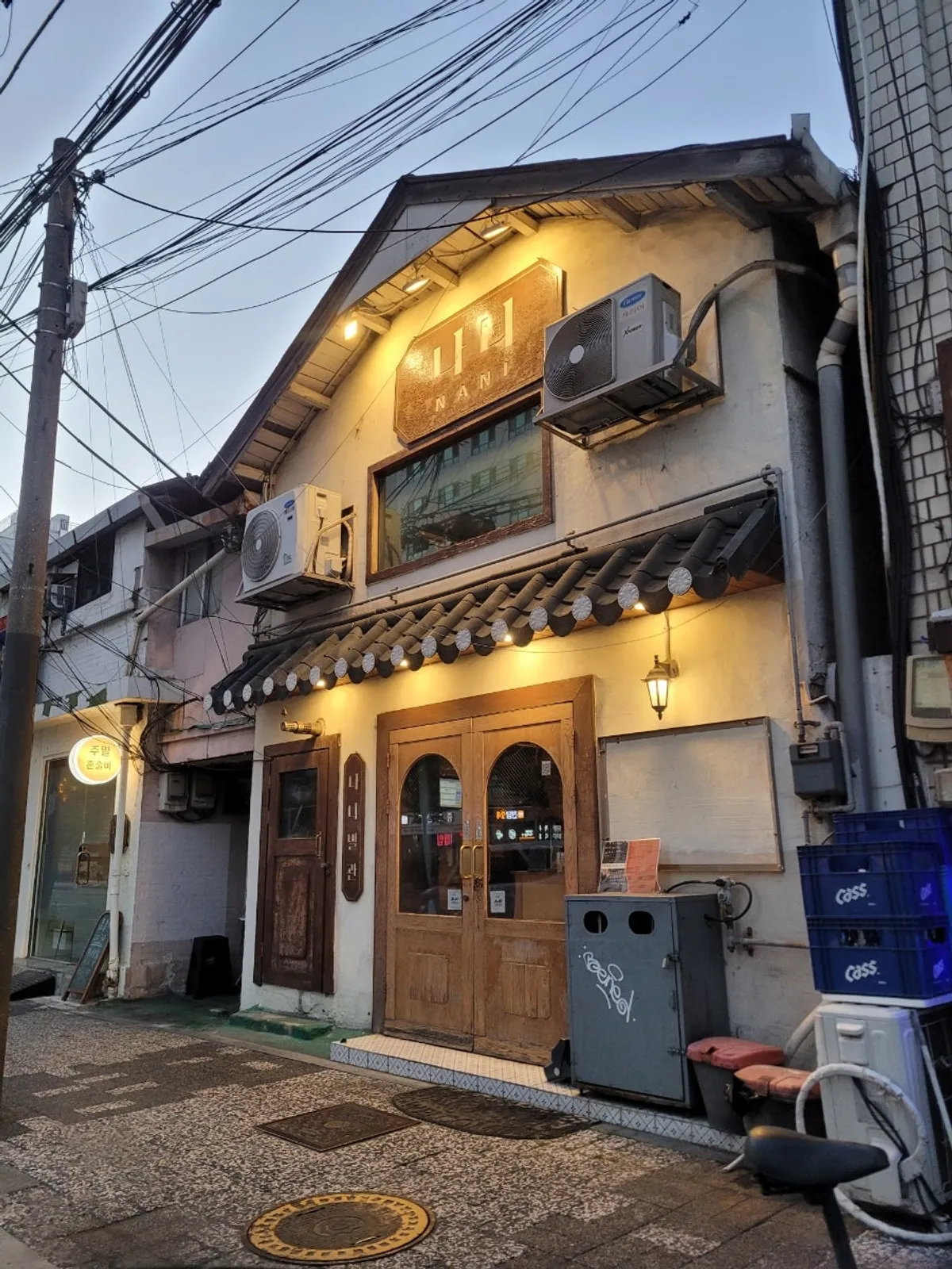 Tiled-roof-style eaves and yellow lighting on the standalone two-story exterior of Nani Byeolgwan Yeongdeungpo Branch