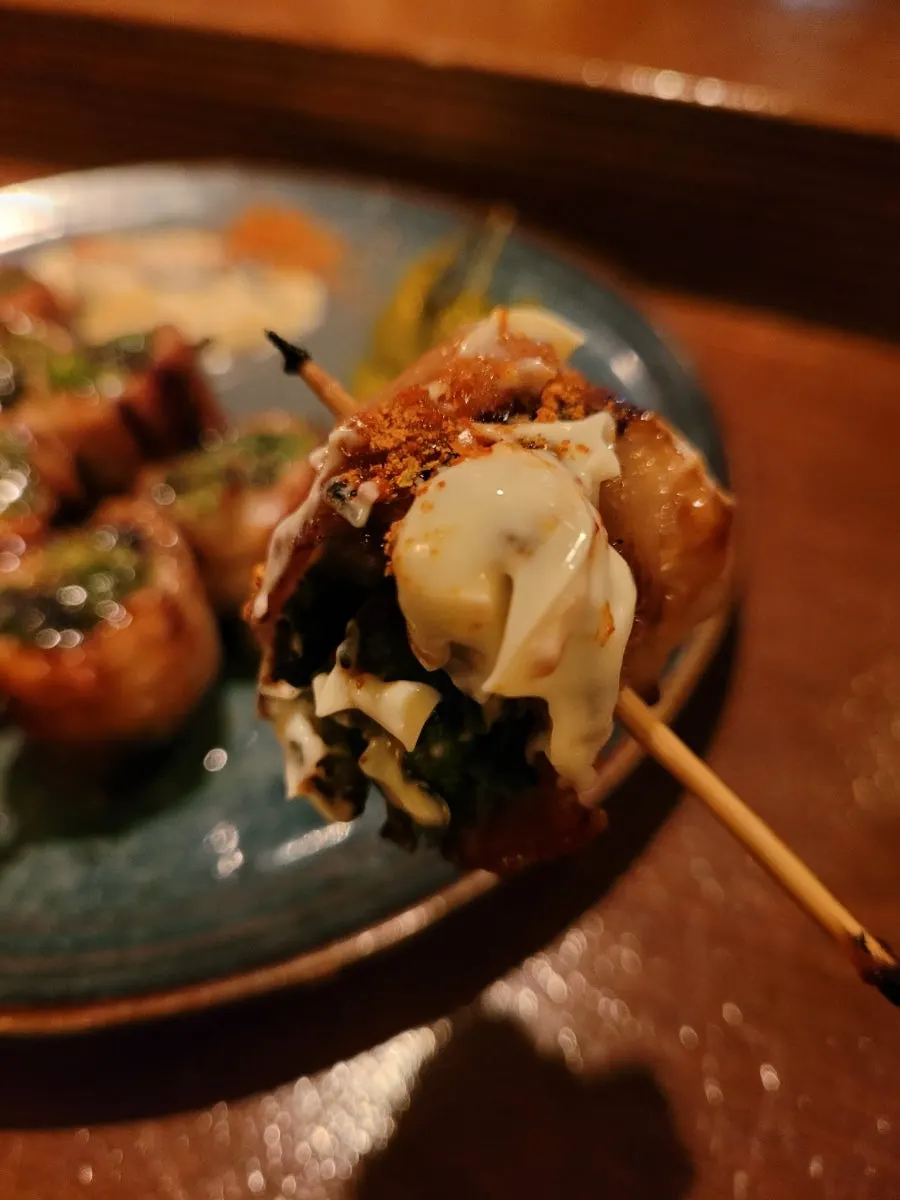 Cross-section of a pork belly skewer packed full of scallions