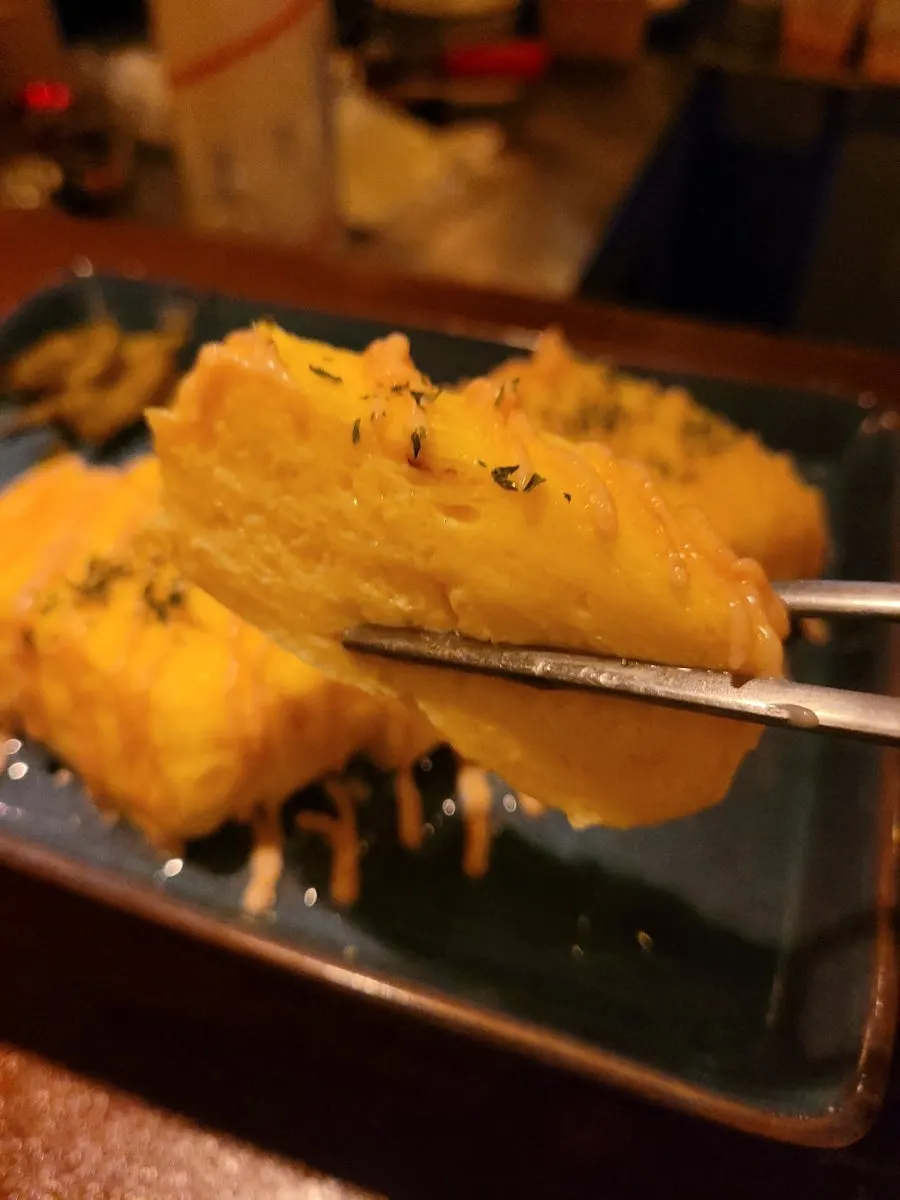 Cross-section of egg roll covered in mentaiko-mayo sauce