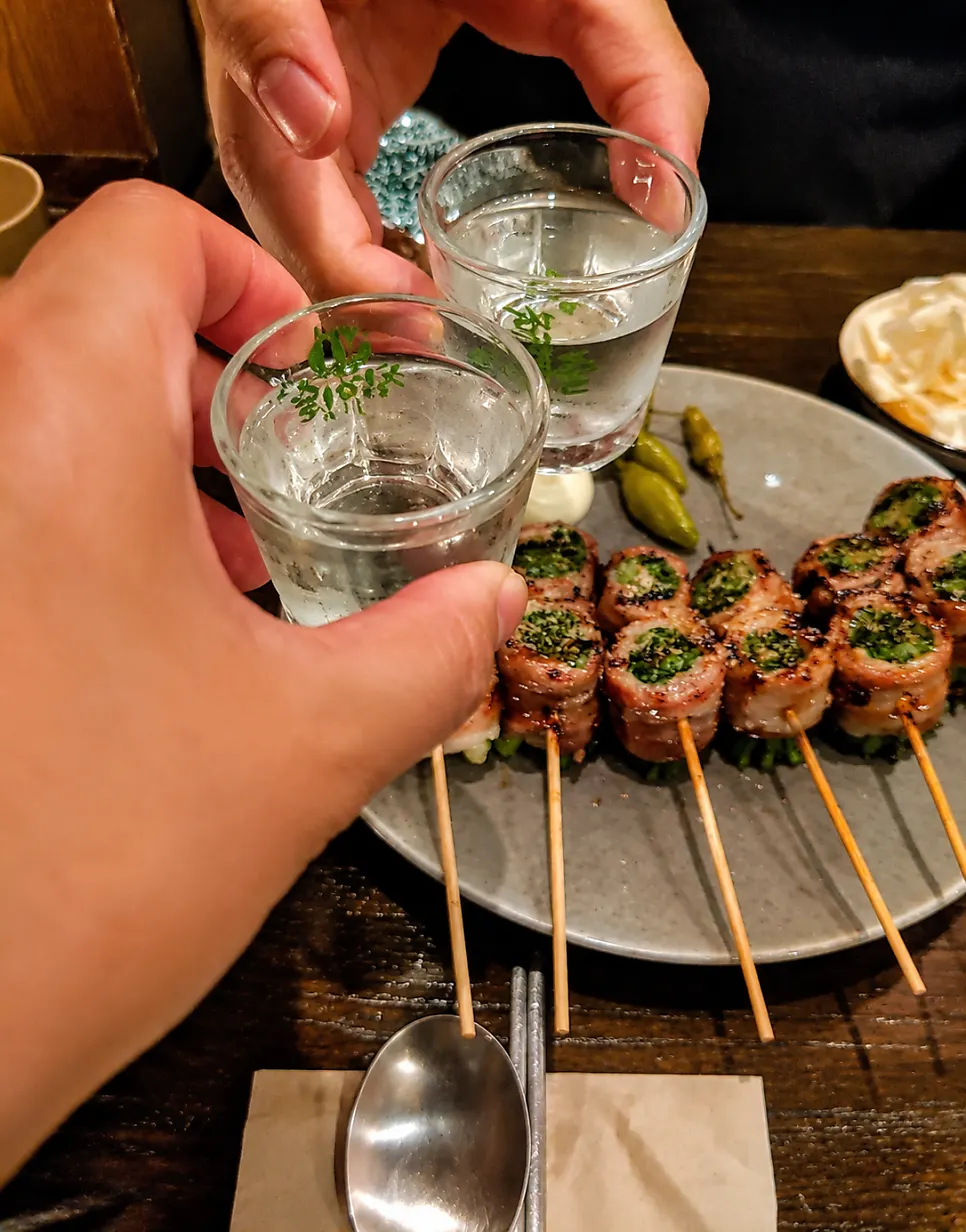 Close-up of a pork belly scallion skewer topped with teriyaki sauce