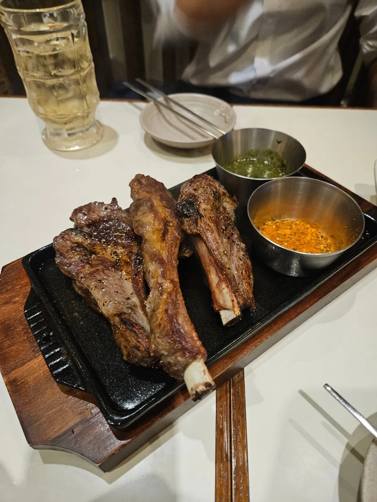 Lamb shoulder rack table setting with green sauce