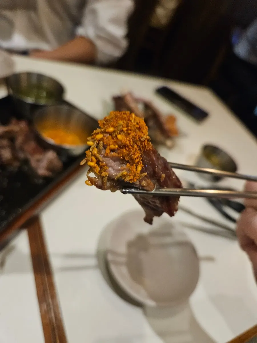 Holding up a piece of the lamb shoulder rack