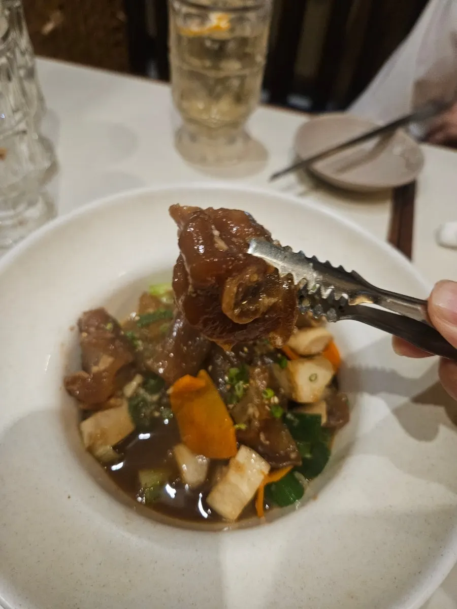 Picking up a piece of tender tendon with chopsticks