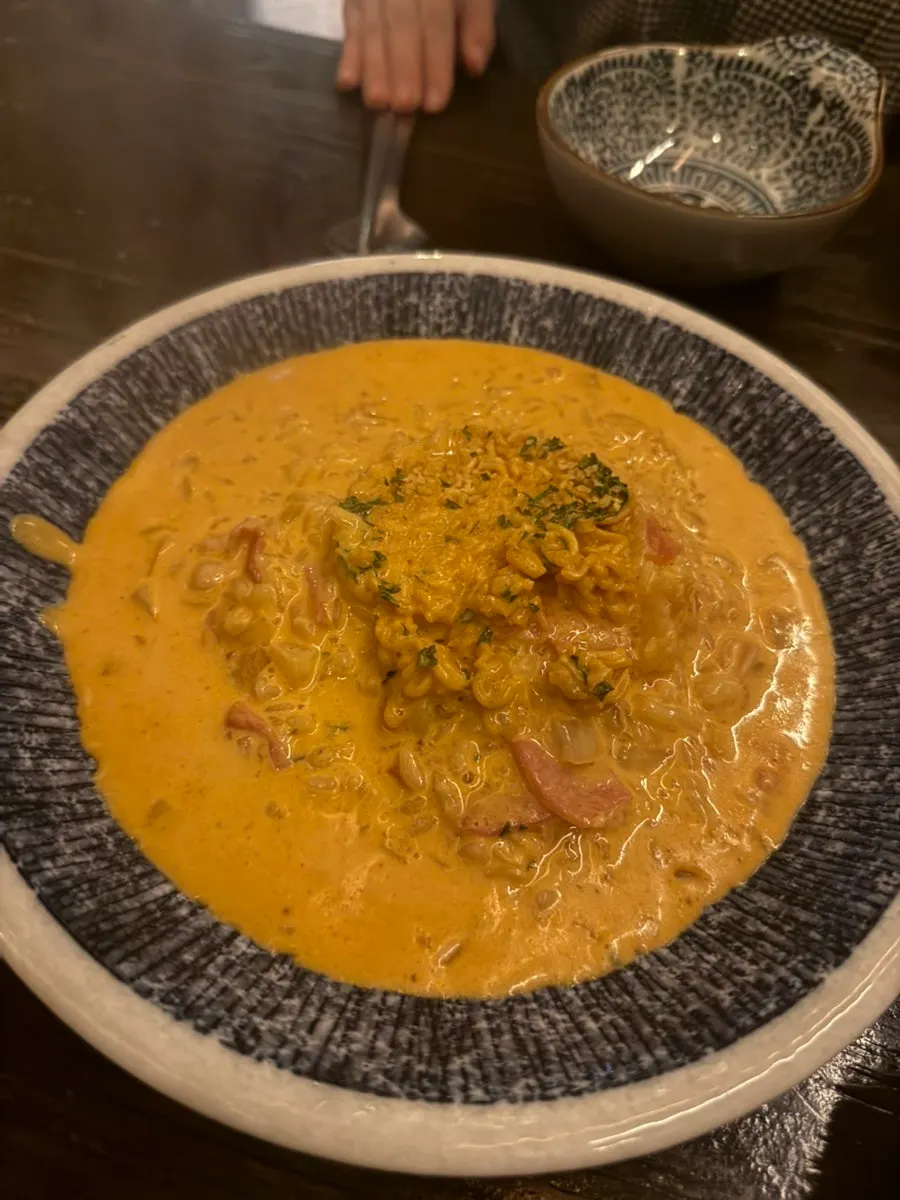 Sinramyeon risotto topped with ramyeon over cream sauce