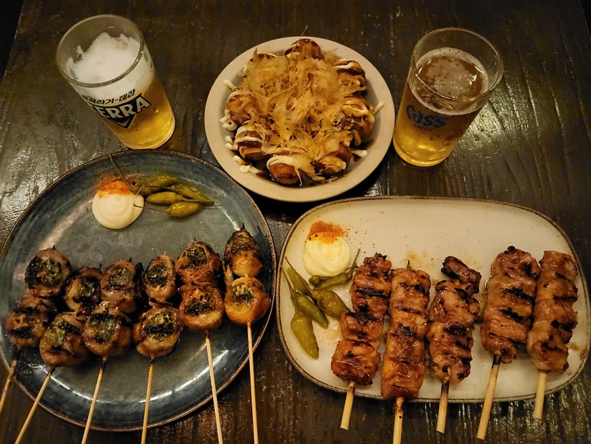 꼬치와 타코야끼, 카스 병맥주가 놓인 테이블