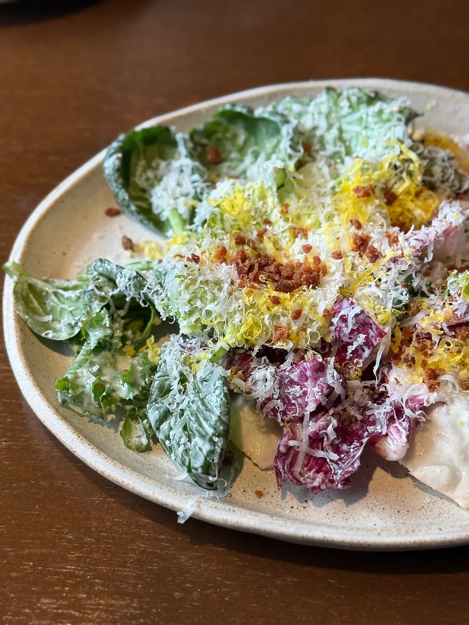Romaine Caesar salad topped with bacon and parmesan