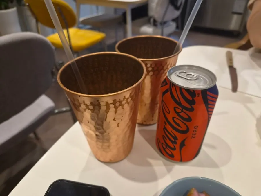 Coke served with two ice-filled glasses