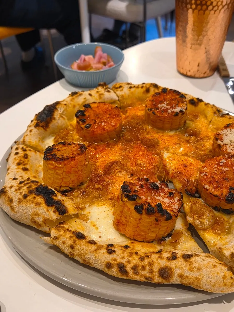 Close-up of the pizza showing corn and shrimp