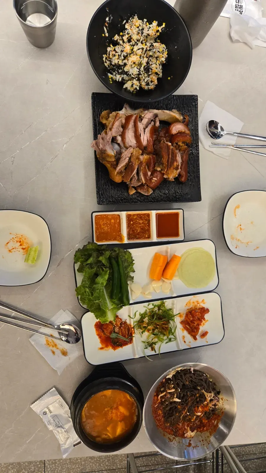 Full table spread with small jokbal, noodles, and sundubu-jjigae