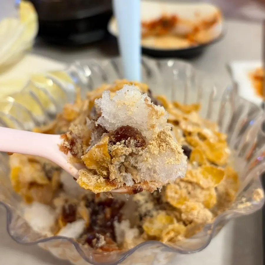 Shaved ice topped with cereal, bean powder, red beans, and condensed milk