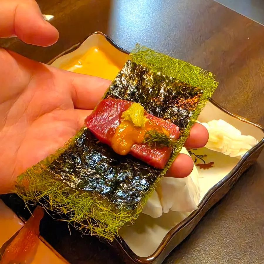 One-bite combination of tuna, uni, and salmon roe