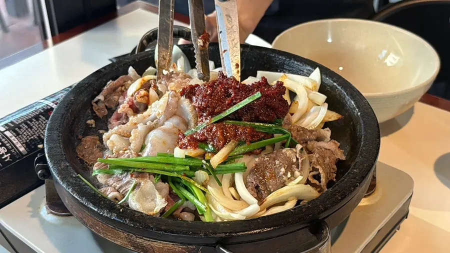Live octopus and beef stone grill being cooked at the table
