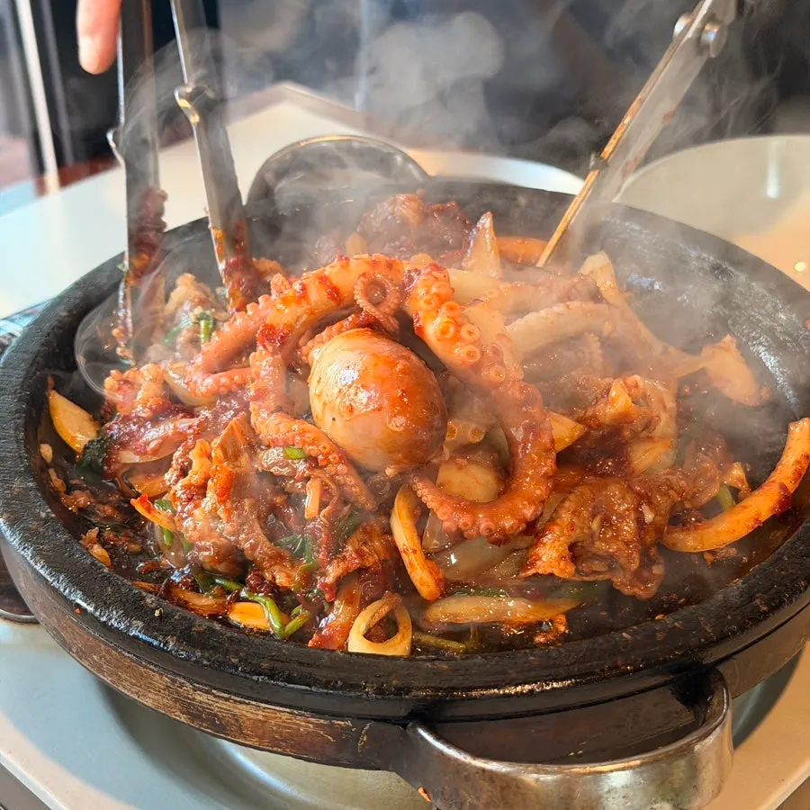 Scene of the live octopus and beef stone grill being cooked
