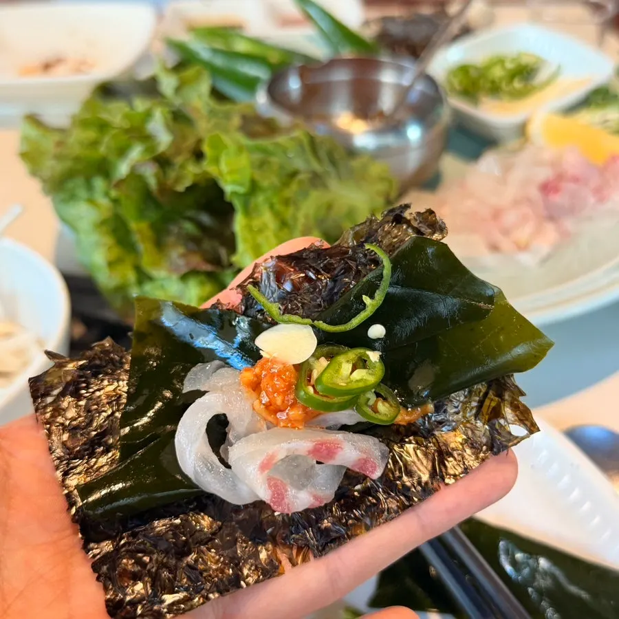 Sea bream sashimi wrapped in seaweed and sea greens