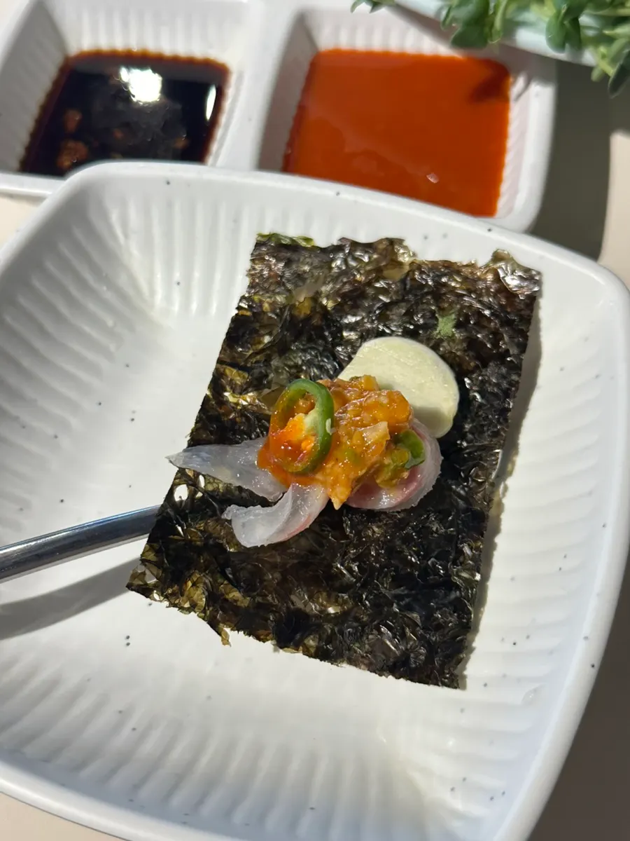 包著生拌魚準備入口的畫面