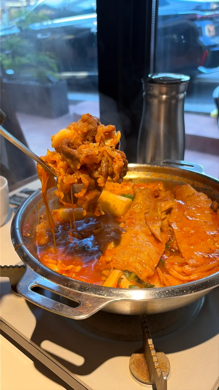 Lifting up a rice cake from the beef brisket tteokbokki