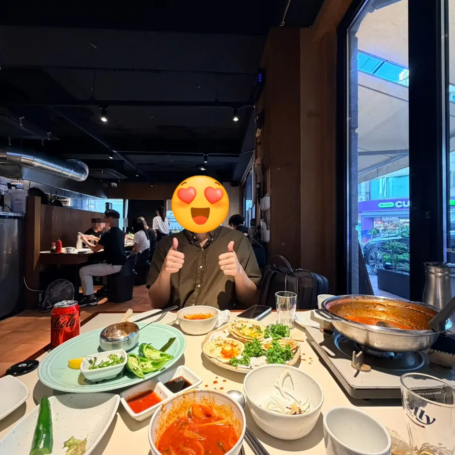 Table with sashimi, grilled scallops, and tteokbokki together