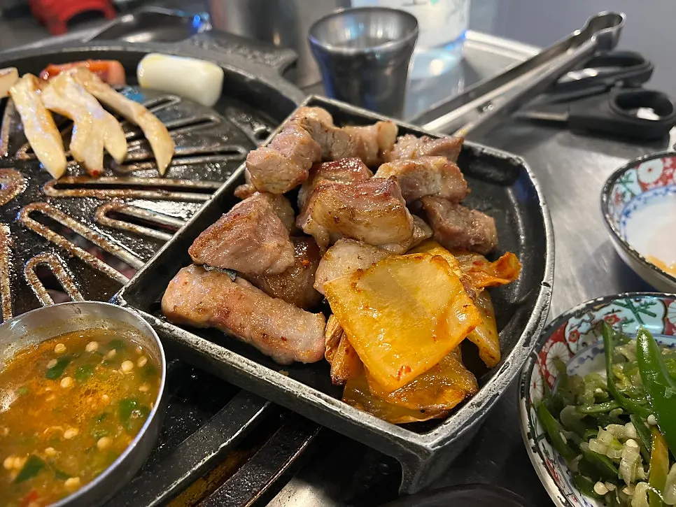 鉄板の縁の四角いプレートに置いた焼き上がった肉
