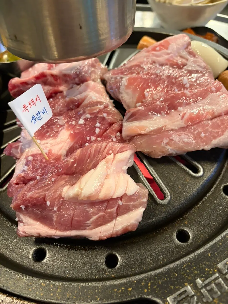 Table set with the ordered Sancheong black pork raw ribs and grilled vegetables