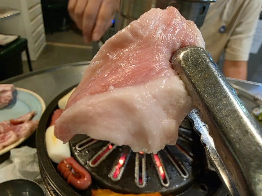 Thick samgyeopsal laid out lengthwise on the griddle
