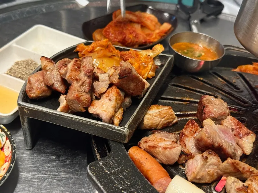 Fully cooked meat and kimchi placed on the cast-iron plate