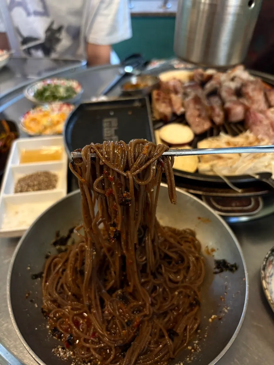 A bite of grilled meat topped with aged kimchi