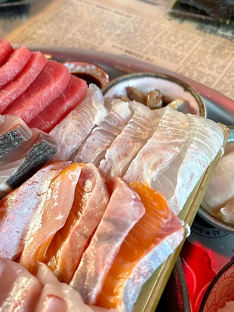 A bite of aged raw fish wrapped in a lettuce leaf