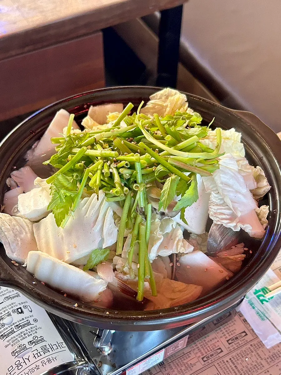 The complimentary clam soup served in a stone pot