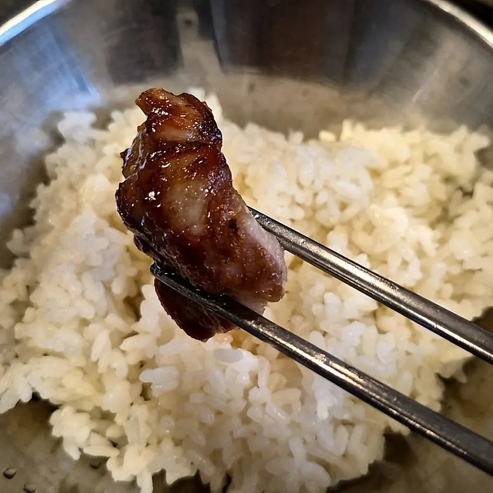 밥에 고기와 반찬을 올린 한 숟갈