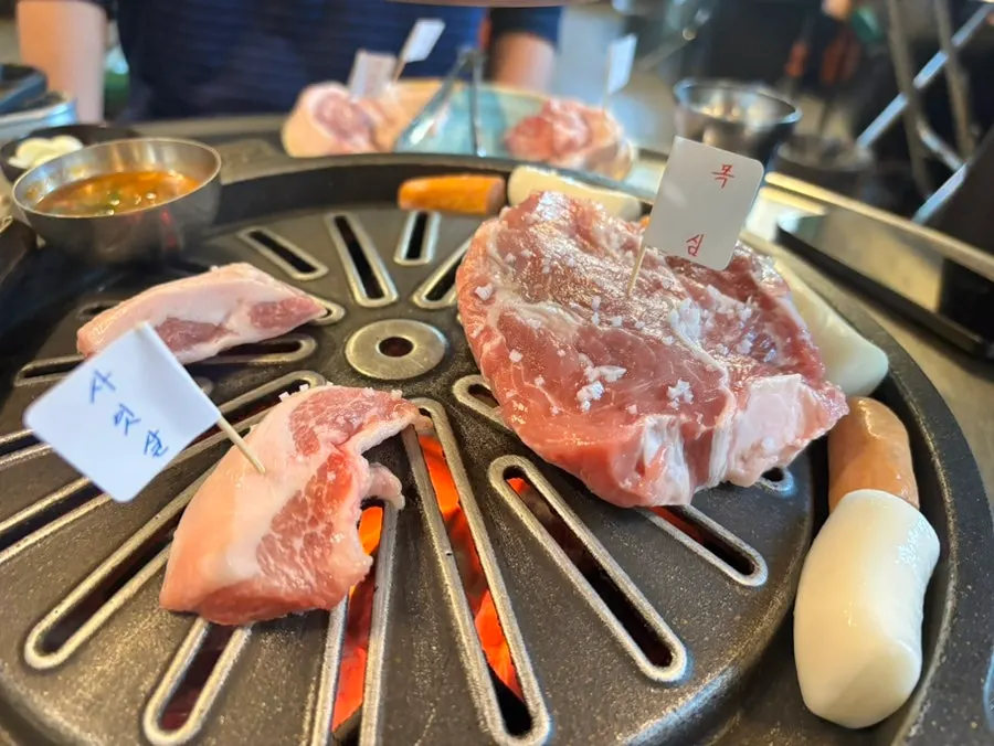 Various cuts of the mixed grill cooking on the grill plate